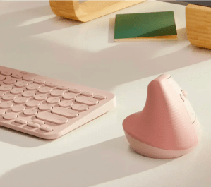 Pink vertical mouse on desk next to pink keyboard